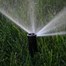 Picture of a sprinkler spraying water onto a field of grass