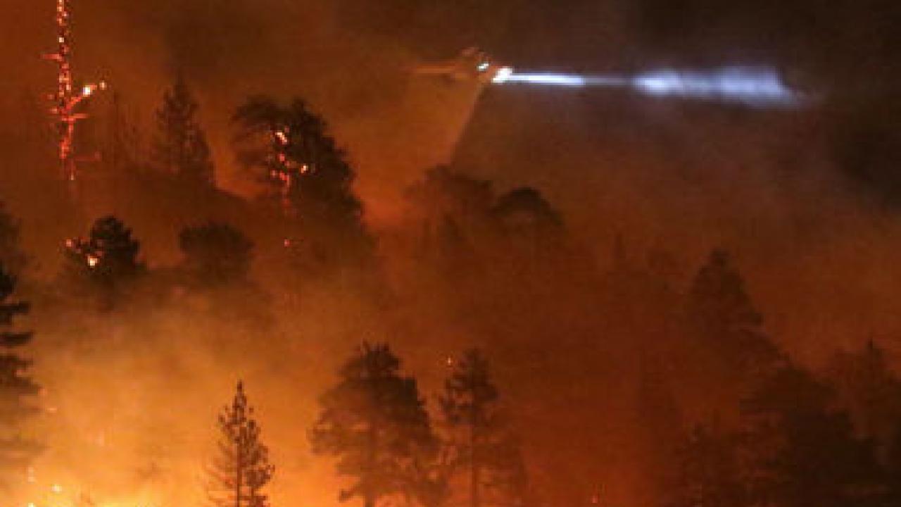 Los Angeles county fire helicopter makes a water drop to battle wild land fire call the Pine Fire in Wrightwood, Calif., on July 17. A late night brush fire broke out near the Mountain High ski resort Friday in the hills of the Angeles Forest.